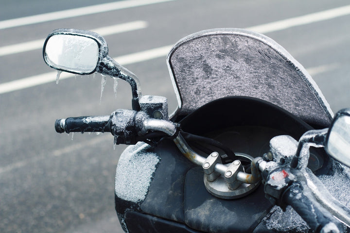 Motorcycle with frost on windshield and grips in winter