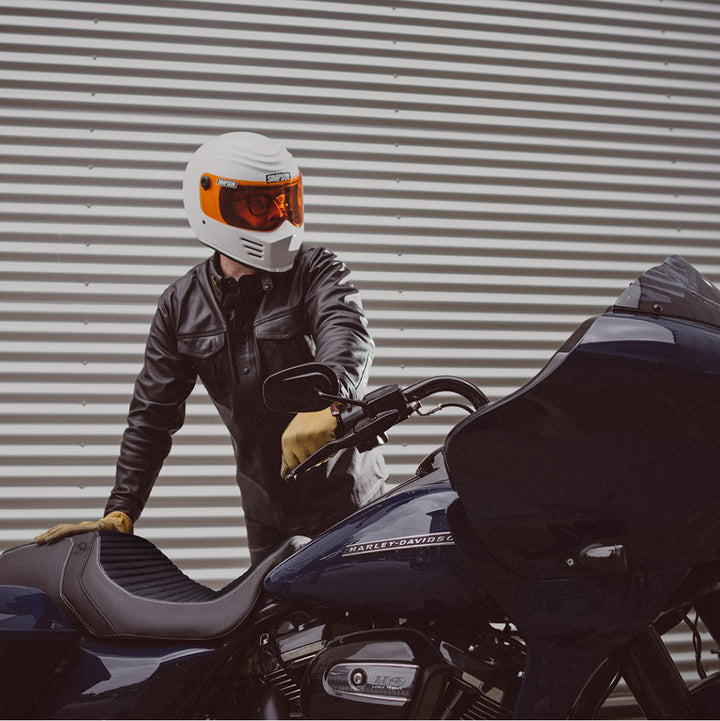 Biker in white helmet standing next to his blue harley davidson bike with Luimoto seat cover